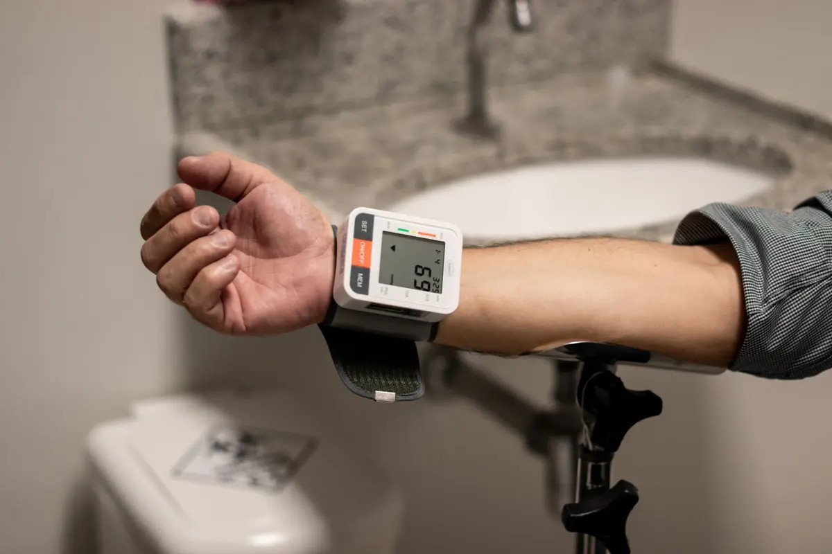 Person checking blood pressure with a wrist monitor, a key step to prevent brain stroke