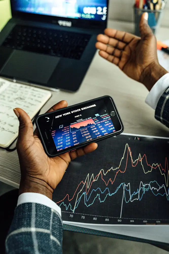Hands holding a smartphone showing share prices, checking the Jio share price today after the Jio IPO listing gain