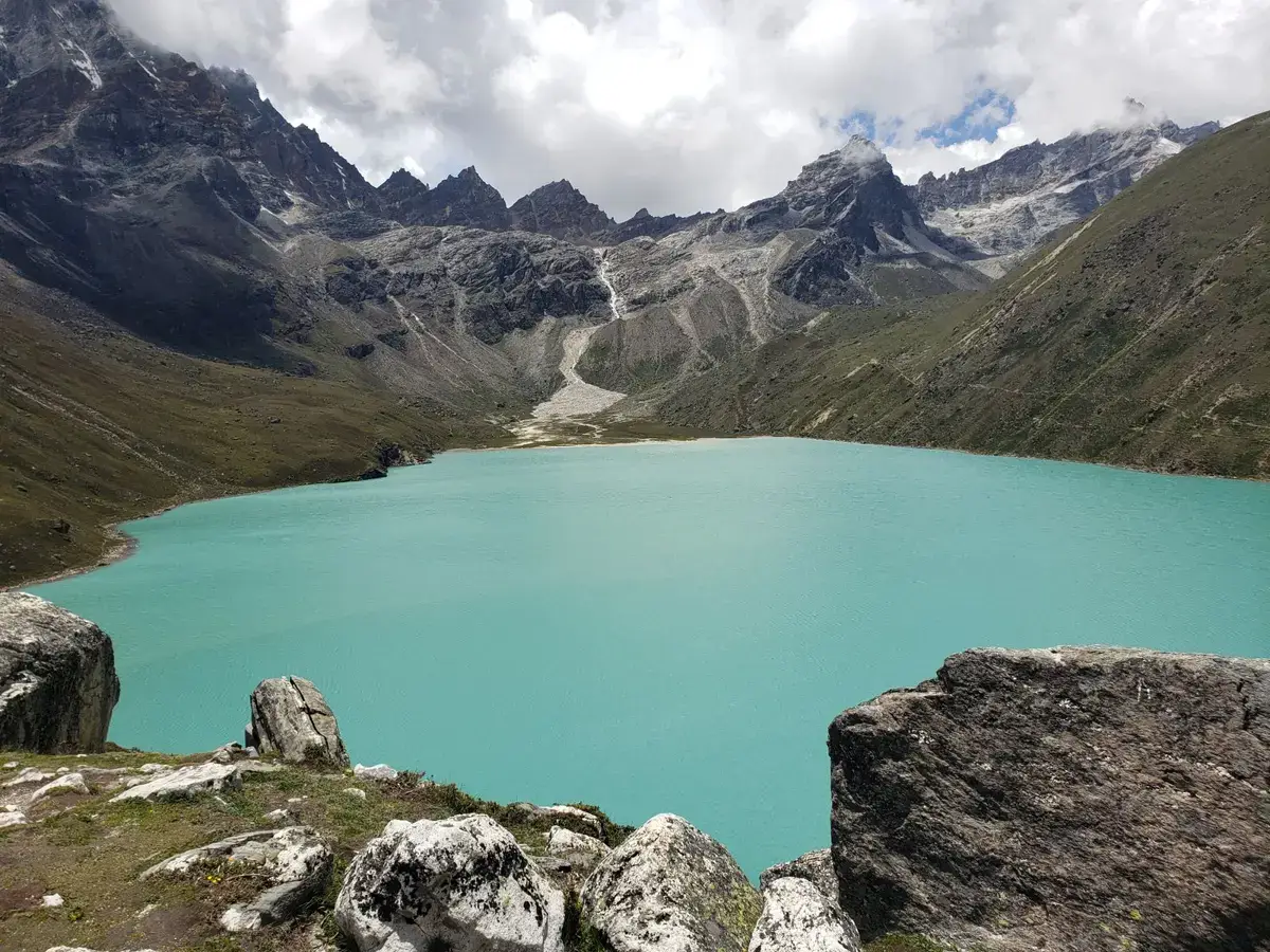 Turquoise glacial lake held back by rocky moraine in the Himalayas, the kind of lake that can cause a glacial lake outburst flood