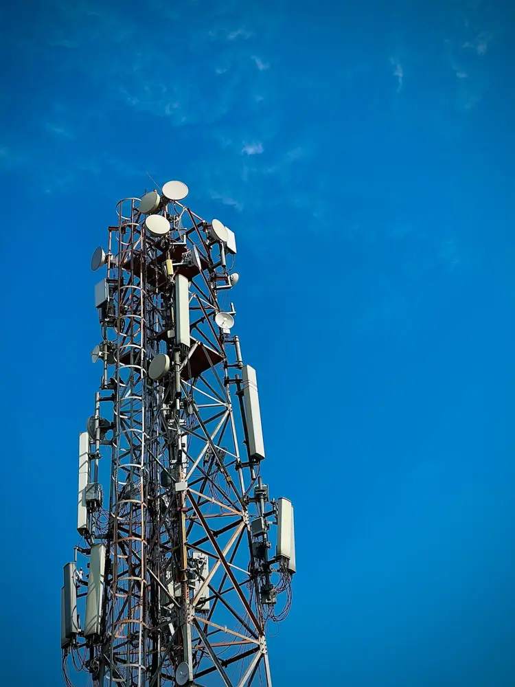 Telecom tower with mobile antennas against a blue sky in Punjab, India, the network behind Jio's business